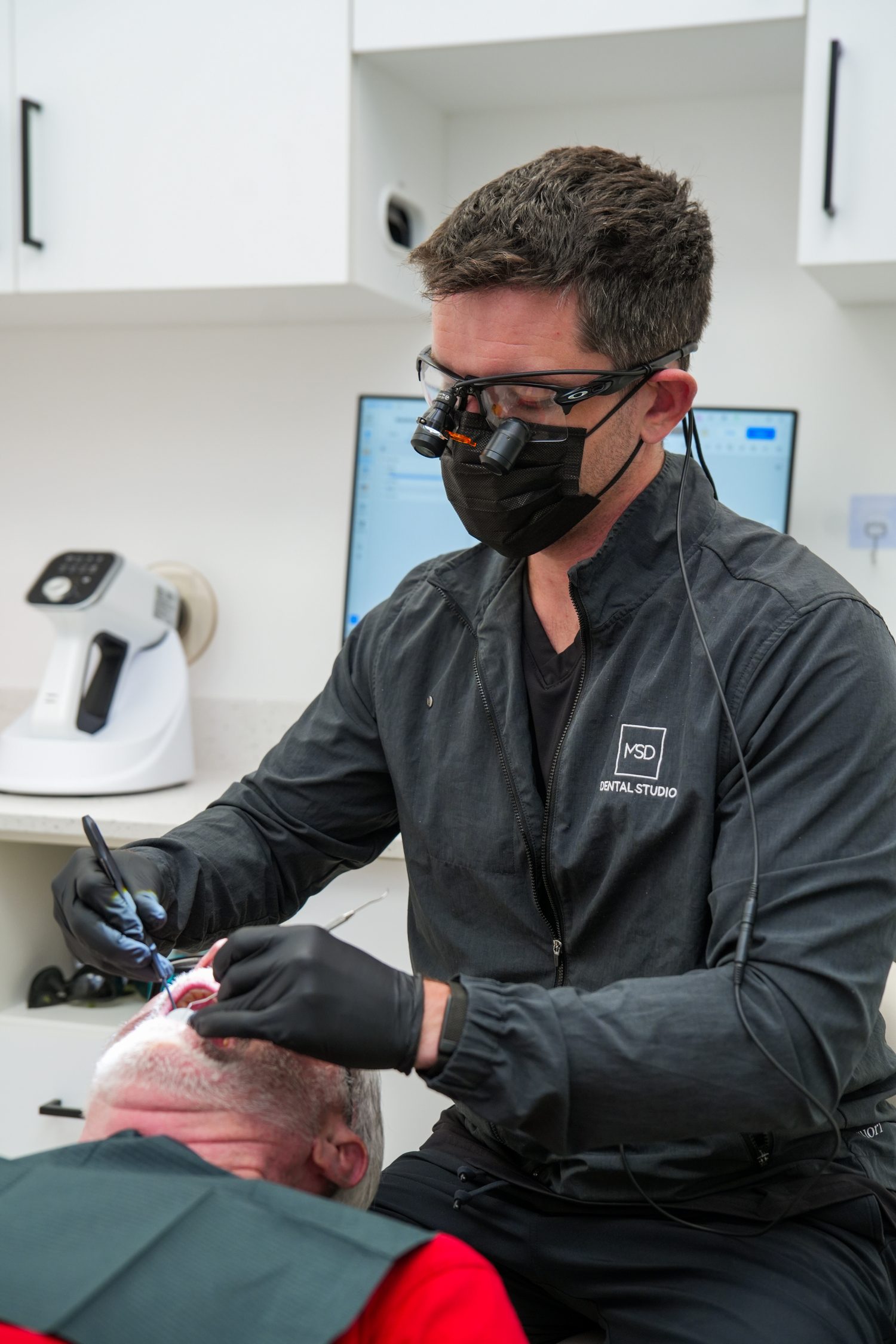 El Dr. Dillon realizando un tratamiento restaurador junto al sillón en MSD Dental Studio, Coral Springs